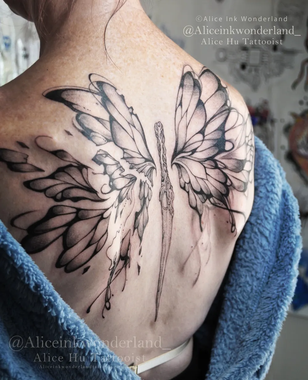 Freehand wings with a dagger tattoo across a back, by Alice Ink Wonderland